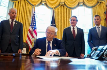 President Donald Trump signs an executive order in the Oval Office as officials look on amid new citizenship revocation plans