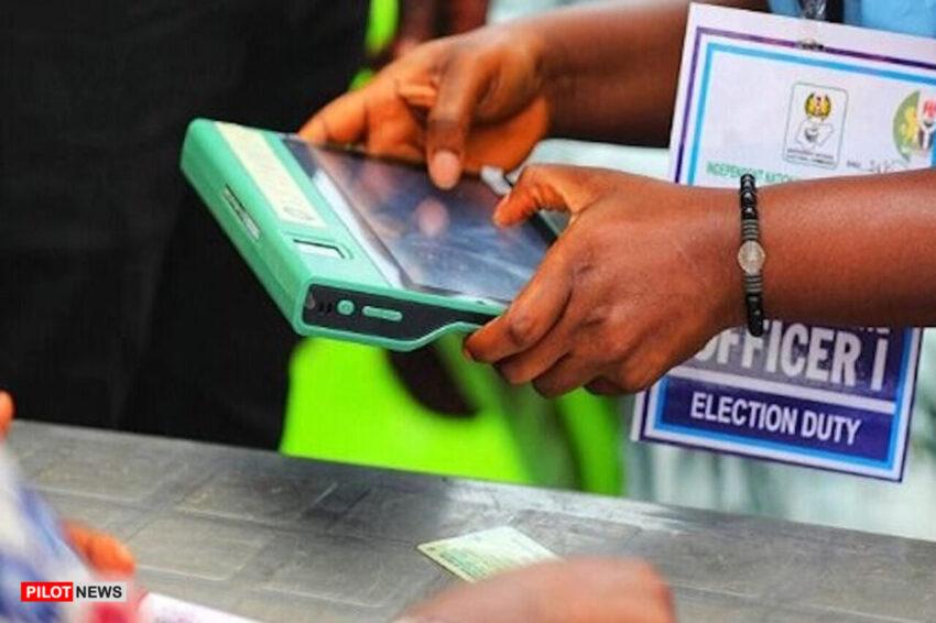 An INEC official using the Bimodal Voter Accreditation System (BVAS) to verify a voter during an election in Nigeria.